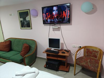 פינת ישיבה עם טלוויזיה חכמה ומחשב – אירוח רומנטי בעין כרם