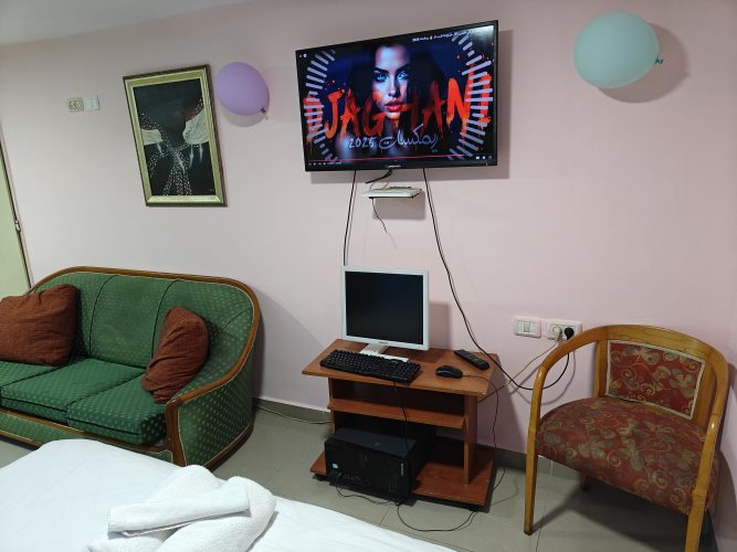 פינת ישיבה עם טלוויזיה חכמה ומחשב – אירוח רומנטי בעין כרם